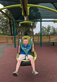 a boy with Down syndrome smiles on the adaptive zipline in Willmar Minnesota's Destination Playground